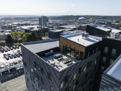 a building with a rooftop terrace and a city in the background at Moraine, Tacoma, Washington