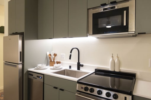 a kitchen with a sink and a stove and a microwave at Moraine, Tacoma, Washington 98402