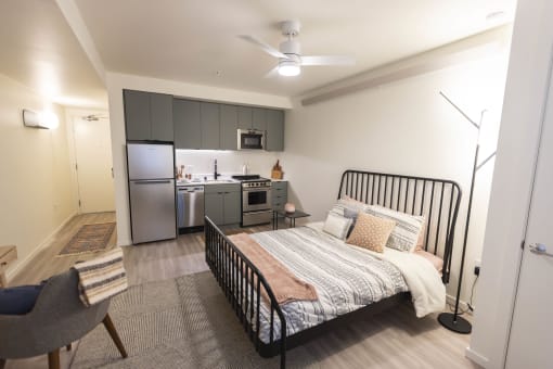 a bedroom with a bed and a kitchen at Moraine, Tacoma, Washington 98402