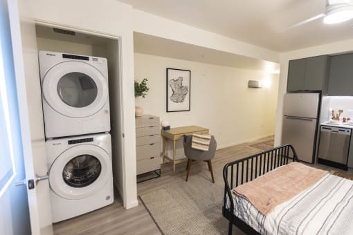 a washer and dryer in a living room with a desk and a kitchen at Moraine, Washington 98402