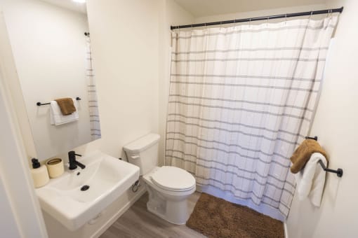 a bathroom with a white toilet and a white sink at Moraine, Tacoma, Washington 98402
