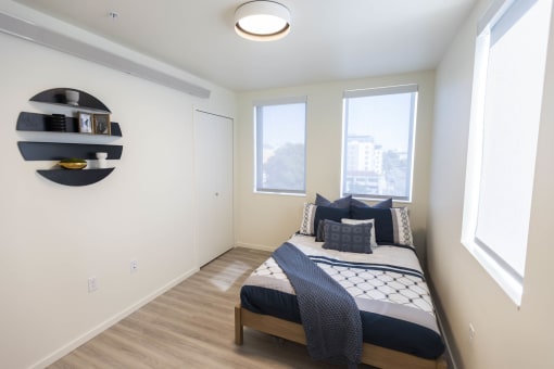 a bedroom with a bed and three windows at Moraine, Tacoma, WA