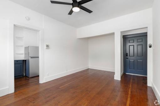 A room with a ceiling fan and a door.