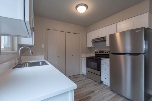 a kitchen with a refrigerator freezer and a stove top oven