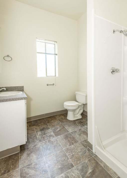 A bathroom with a toilet, sink, and tiled floor.