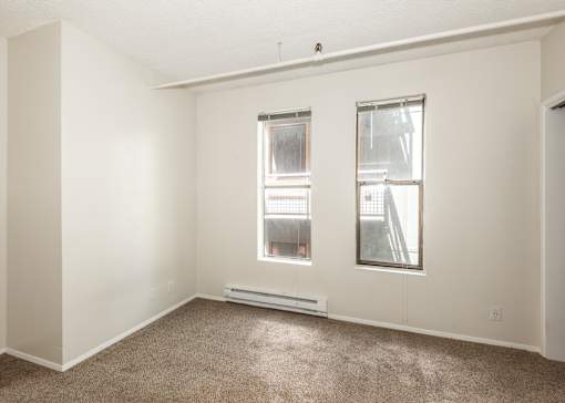 A room with a window and a carpet on the floor.