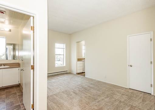 A room with a carpeted floor and a door on the right side.