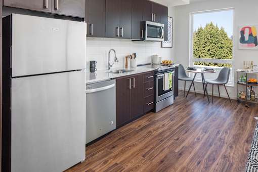 A kitchen with a white refrigerator and wooden floors.