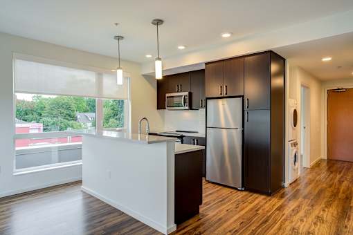 A modern kitchen with dark wood cabinets and a white countertop.