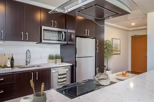 A modern kitchen with dark brown cabinets and a white marble countertop.
