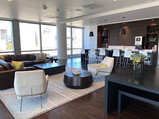 A modern living room with a black coffee table and white chairs.