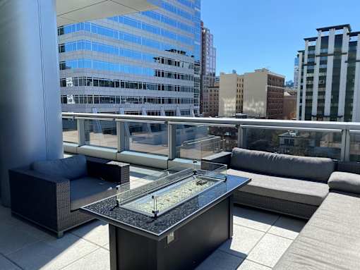 A table with a glass top is in the foreground of an outdoor patio area.