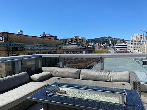 A rooftop patio with a hot tub and couches.