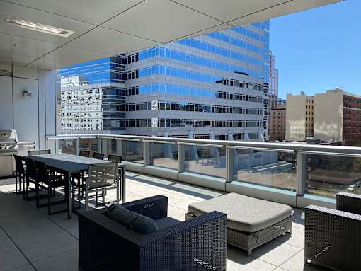 A patio with a table and chairs overlooking a cityscape.