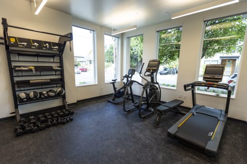 a gym with various exercise equipment in a room with windows at Shift, Oregon, 97217