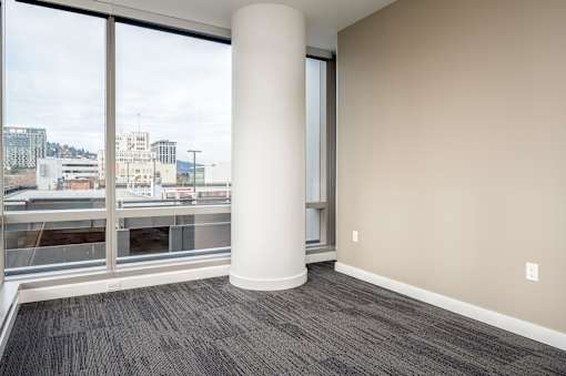A room with a large window and a pillar.
