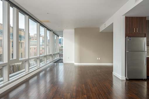 A large empty room with a refrigerator in it.