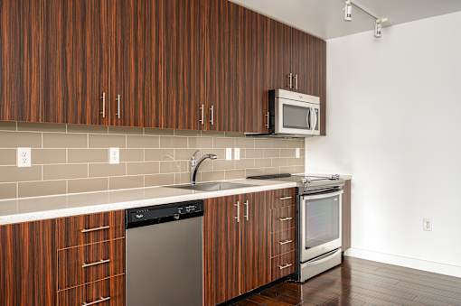 A kitchen with brown cabinets and a white counter.