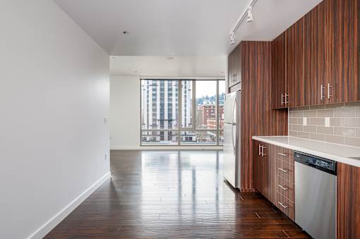 A kitchen with wooden cabinets and a stainless steel dishwasher.