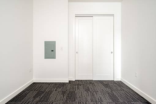 A white door with a grey box on the wall.