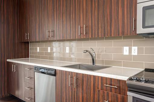 A kitchen with wooden cabinets and a white counter top.