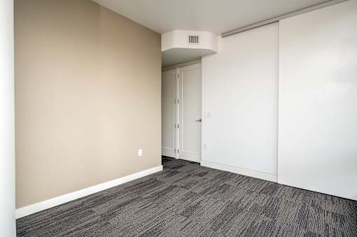 A room with a carpeted floor and a white door.