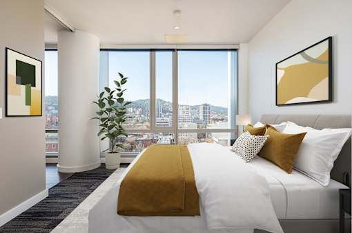 A bedroom with a large bed and a view of the city.
