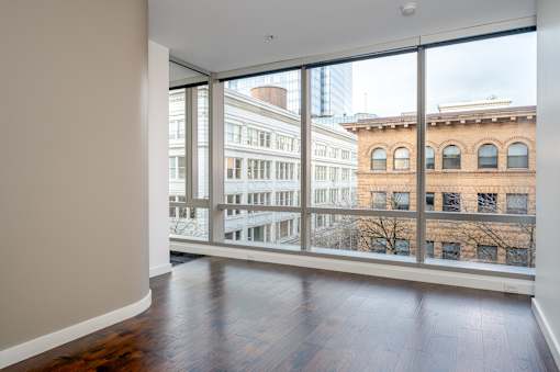 A room with a view of a cityscape through large windows.