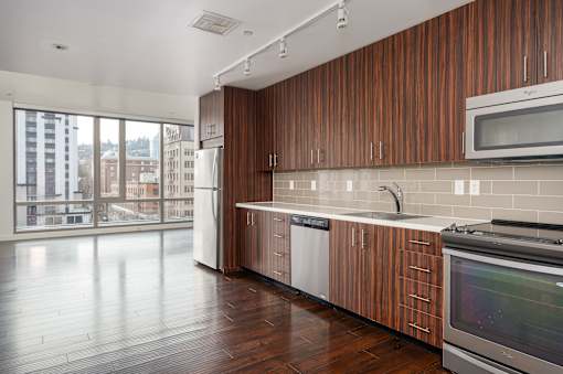 A kitchen with wooden cabinets and a stainless steel oven.