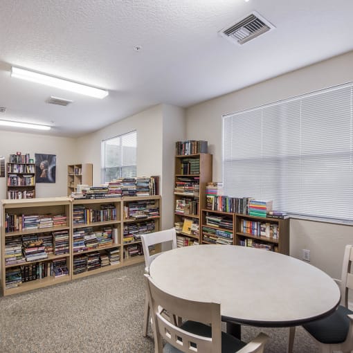 a library with a round table and chairs