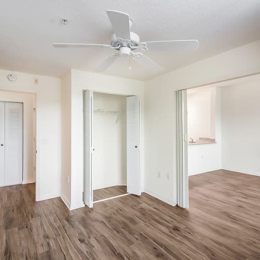 a bedroom with hardwood flooring and a ceiling fan