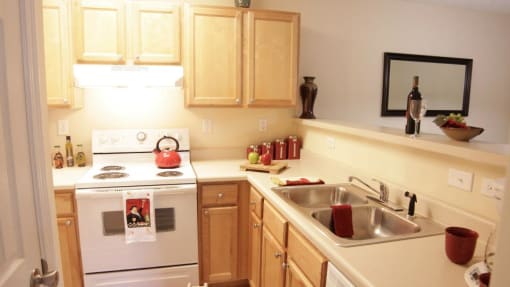 a kitchen with a white stove top oven next to a sink