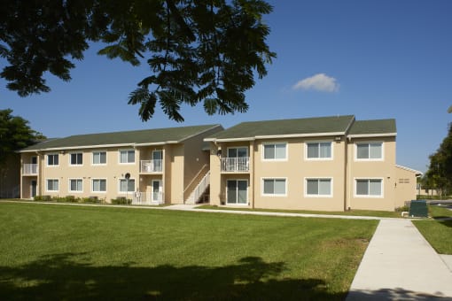 a building with a green lawn and a blue sky