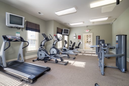 a room filled with cardio equipment and a flat screen tv