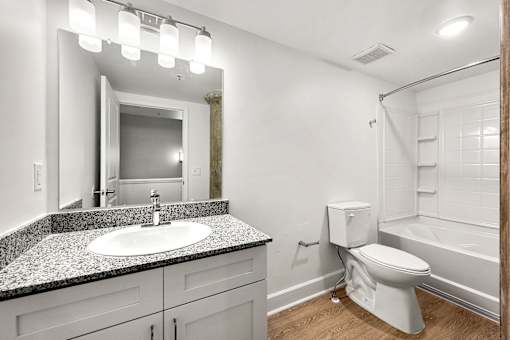 A white toilet sits in a bathroom next to a sink and a mirror.