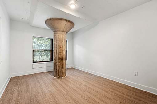 A room with a large column in the middle of it.