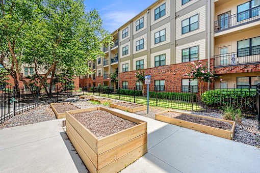 Apartment complex with a garden in front.