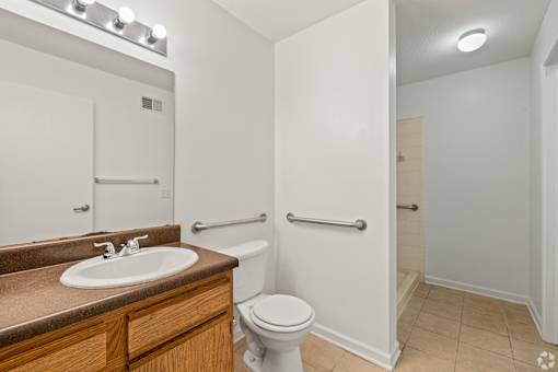 A white toilet sits in a bathroom next to a sink.