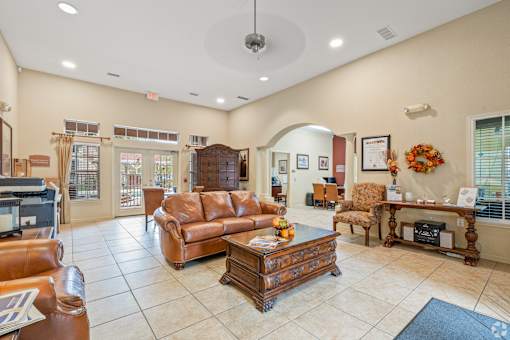 A living room with a brown leather couch and a wooden coffee table.