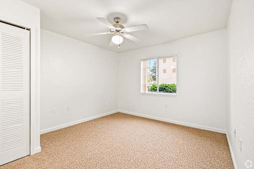 A room with a window and a ceiling fan.