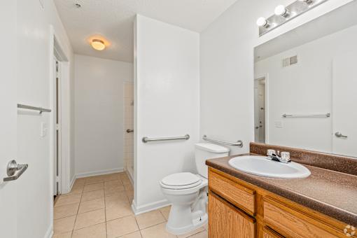 A white toilet sits in a bathroom next to a sink.