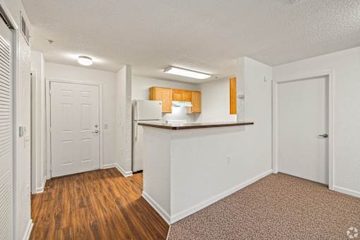 A white kitchen with wooden floors and white walls.