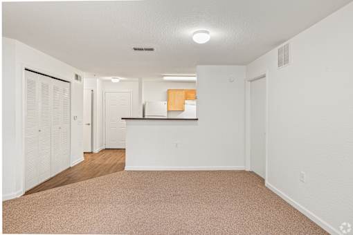 A white room with a brown carpet and a white counter.