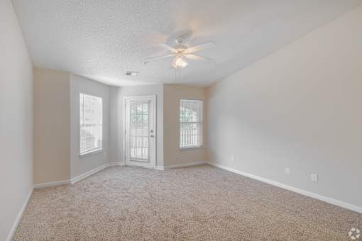 A room with a ceiling fan and carpeted floor.