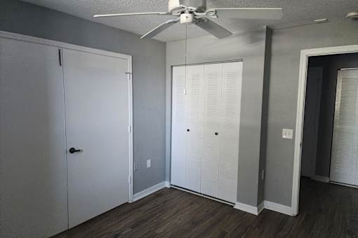A room with a ceiling fan and a door.