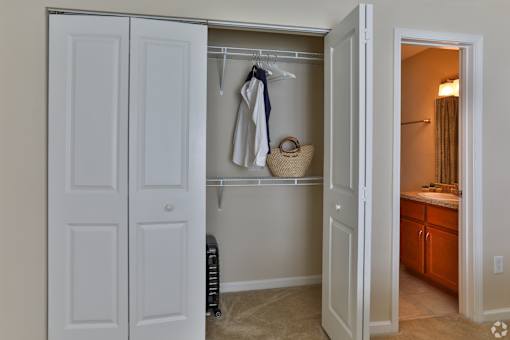 A white closet with a towel hanging on a hanger at The Bristol Apartments, Greenville