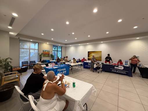 A group of people are gathered around tables in a room.