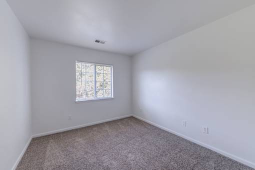a bedroom with white walls and a window at Carolina Springs Apartments, Carrboro, NC 27510  