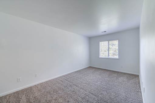 a living room with white walls and a window at Carolina Springs Apartments, 27510  