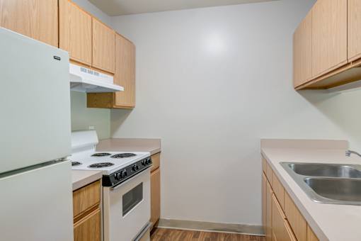 a kitchen with white appliances and wooden cabinets at Carolina Springs Apartments, North Carolina, 27510